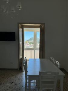 a dining room with a table and chairs and a window at Domus Ambrosia in Bacoli +19 photos