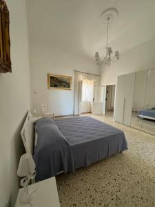 a bedroom with a bed with a blue blanket at Domus Ambrosia in Bacoli