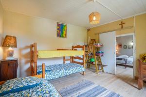 a bedroom with a bunk bed and a cross on the wall at La Pause - A moins d1 Km de la plage in Tour-de-Faure