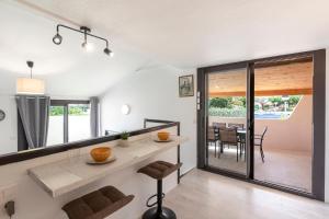 a kitchen and dining room with a table and chairs at L'Ornano - Maison climatisée avec piscine in Grosseto-Prugna