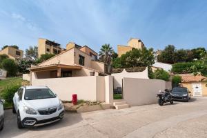 a car and a motorcycle parked in front of a house at L'Ornano - Maison climatisée avec piscine in Grosseto-Prugna