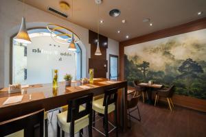 a restaurant with a bar with chairs and a large painting at Abba Rambla Hotel in Barcelona
