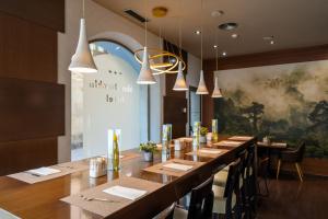a restaurant with wooden tables and chairs and a large window at Abba Rambla Hotel in Barcelona