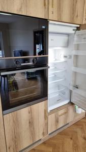 an empty kitchen with an open refrigerator at Apartament w Centrum Luksusowy, Klimatyzacja, Full Opcja, Zameldowanie 24h, Duży Parking, Balkon, PlayStation 5, Ekspres, Netflix, Winda, FV, Nowy Budynek in Starogard Gdański +25 photos