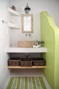 a bathroom with a sink and a green wall at Blue Bay Patmos Summer House in Grikos
