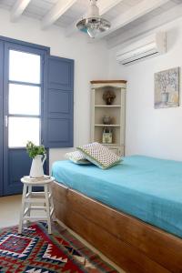 a bedroom with blue doors and a bed with a stool at Blue Bay Patmos Summer House in Grikos