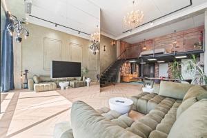 a large living room with a couch and a tv at ALL - Amberstone Lux Loft in Klaipėda
