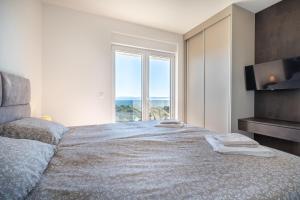 a bedroom with a large bed with a large window at Villa La Vista e Bella in Kožino +87 photos