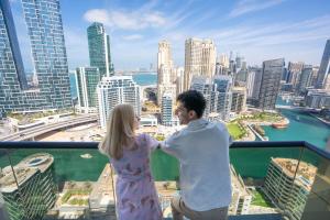 a man and a woman standing on top of a building at The First Collection Dubai Marina in Dubai