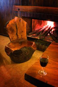 a glass of wine sitting on a table next to a fireplace at Hotel Rural La Cabaña in Palazuelos