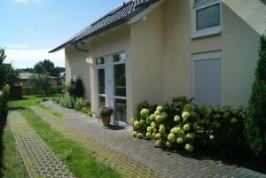 a house with a row of bushes in front of it at Ferienwohnungen im Haus Bi Henny in Baabe +44 photos