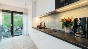 a kitchen with a counter with a vase of flowers at VacationClub - Jana Matejki 1 Apartament 1 in Karpacz