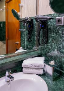 a bathroom with a sink and a mirror and towels at Abba Rambla Hotel in Barcelona