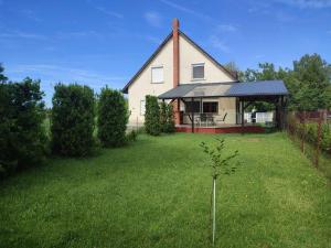 a house with a small tree in the yard at Holiday home in Balatonkeresztur 44886 in Balatonkeresztúr