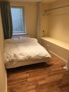 a bedroom with a bed and a window and a tub at Spacious duplex flat in London