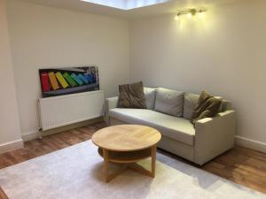 a living room with a couch and a table at Spacious duplex flat in London