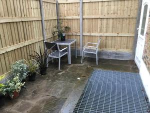 a patio with a table and two chairs and a fence at Spacious duplex flat in London