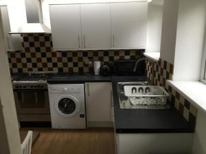a kitchen with a sink and a washing machine at Spacious duplex flat in London