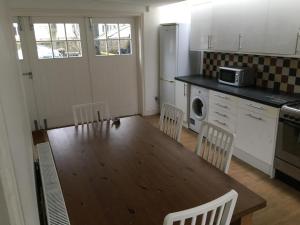 a kitchen with a wooden table and chairs in a kitchen at Spacious duplex flat in London