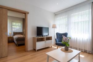 a living room with a tv and a blue chair at Ośrodek Wypoczynkowy Zacisze in Śliwice