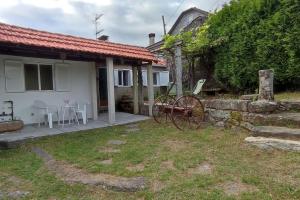 a house with a yard with a bike in front of it at A Riquiña in Mondariz