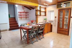 a kitchen with a wooden table and chairs at A Riquiña in Mondariz