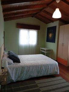 a bedroom with a bed and a window at A Riquiña in Mondariz