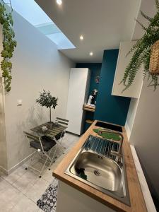 a kitchen with a sink and a table at Appartement 2 personnes romantique tout confort alentours Boulogne sur mer 3 etoiles in Samer +15 photos