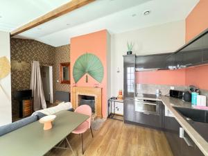 une cuisine et un salon avec un canapé et une table dans l'établissement Maison Évasion Vichy14 couchages, à Vichy