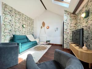 un salon avec un canapé bleu et une télévision dans l'établissement Maison Évasion Vichy14 couchages, à Vichy
