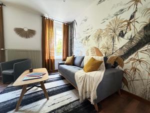 un salon avec un canapé et une table dans l'établissement Maison Évasion Vichy14 couchages, à Vichy