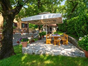 a patio with a table and an umbrella at Apartment Marijo by Interhome in Matulji