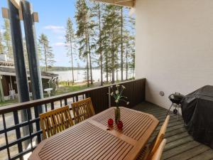 a wooden table on a balcony with a view of the water at Holiday Home Hiisiranta b3 by Interhome in Kolinkylä