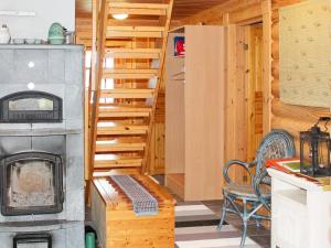 ein Wohnzimmer mit einem Herd und einer Treppe in der Unterkunft Holiday Home Syväniemi by Interhome in Säkkilänvaara + 25 Fotos
