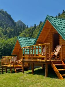 a cabin with a deck and chairs in front of it at Mountain Retreat Jelovica in Kolašin