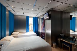 a hotel room with two beds and a television at Stylotel in London +17 photos