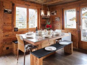 a dining room with a table and chairs and windows at Apartment Praz 11 by Interhome in Verbier