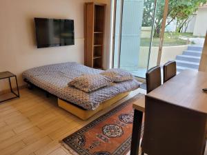 a room with a bed and a flat screen tv at Maison entière en centre ville in Saint-Maur-des-Fossés