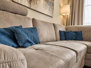 a brown couch with two blue pillows on it at Apartment Horní Mísečky-2 by Interhome in Vítkovice +51 photos