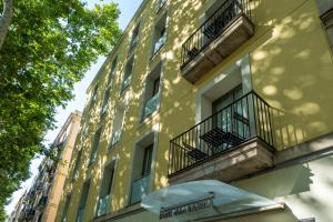 a yellow building with balconies and an umbrella at Abba Rambla Hotel in Barcelona