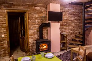 a brick fireplace in a room with a stove at Holiday Home Četri Vēji in Turkalne