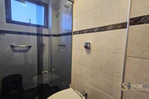 a bathroom with a toilet and a glass shower at Apartamento Piemonte Flat - 105C in Serra Negra +18 photos