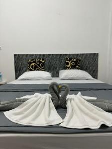 two beds with towels and swans laying on them at Black Sweet Homestay Dua in Gili Air