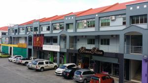 a large building with cars parked in a parking lot at MJ Hotel in Sibuga