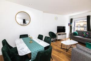 a living room with a table and chairs and a couch at City-Center 2-Bedroom Apartment near Train Station in Dewsbury