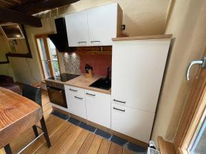 a small kitchen with white cabinets and a table at Ferienhaus Romantica in Bruttig-Fankel für 2 Personen in Bruttig-Fankel