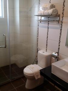 ein Bad mit einem WC, einem Waschbecken und einer Dusche in der Unterkunft MJ Hotel in Sibuga