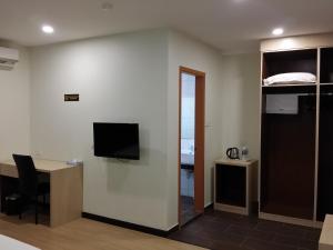 a room with a desk and a tv on a wall at MJ Hotel in Sibuga