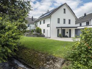 a large white house with a yard at Time Out - Appartement Bodensee in Friedrichshafen