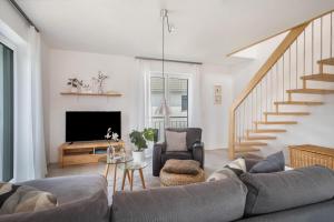 a living room with a couch and a tv at Time Out - Appartement Bodensee in Friedrichshafen